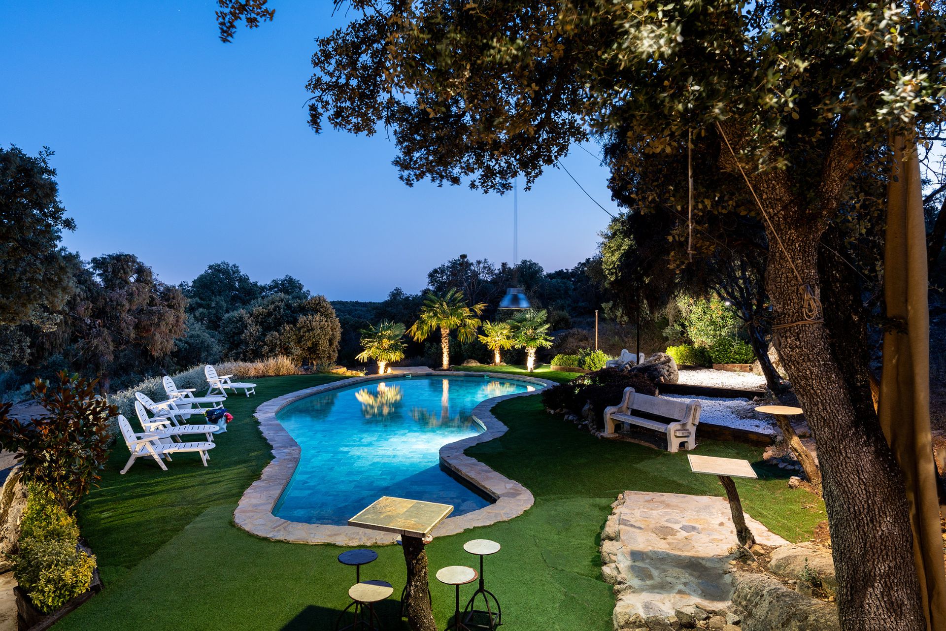 Piscina y jardín iluminados al anochecer