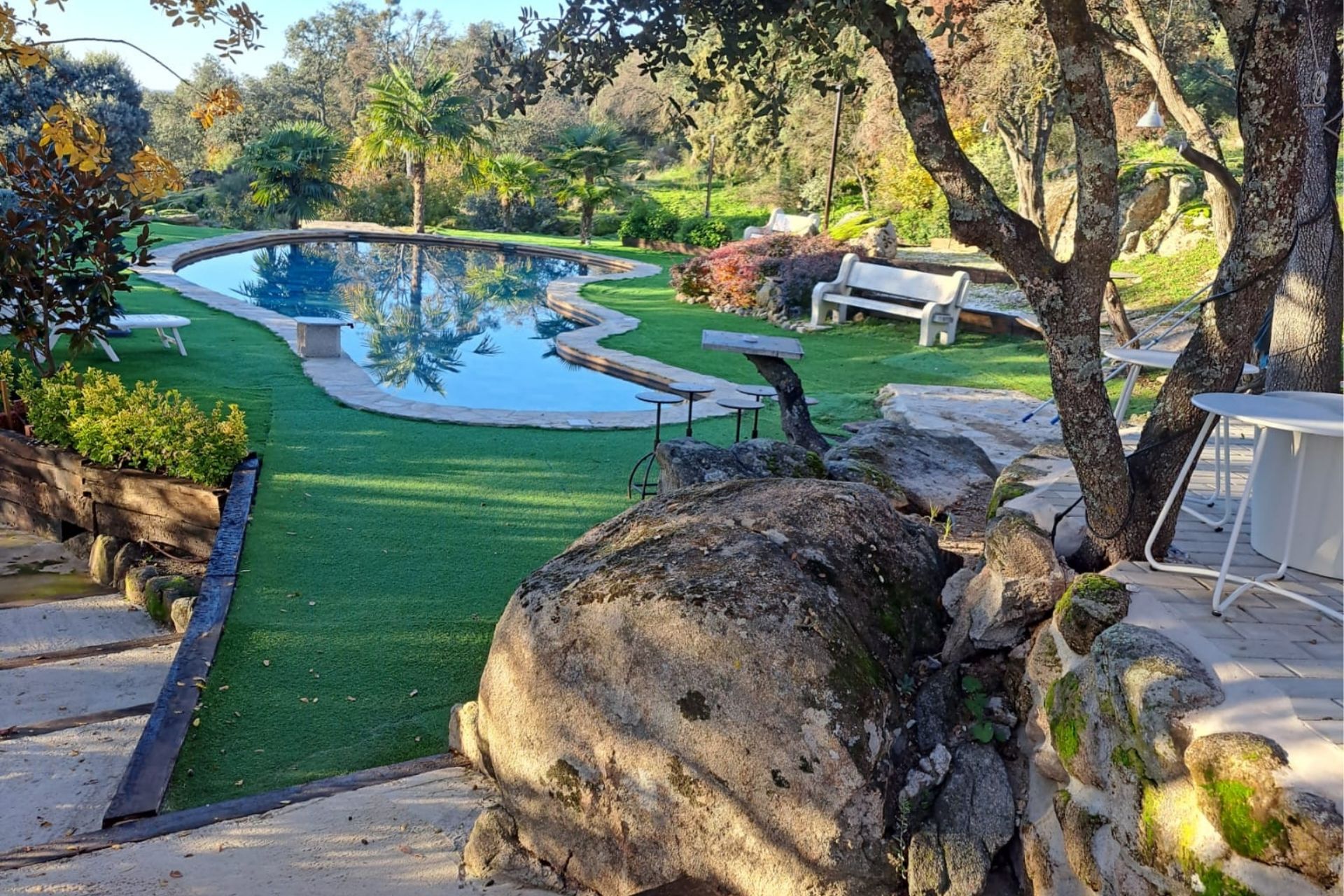 Piscina de Casa de Campo Chana rodeada de árboles y zonas de descanso
